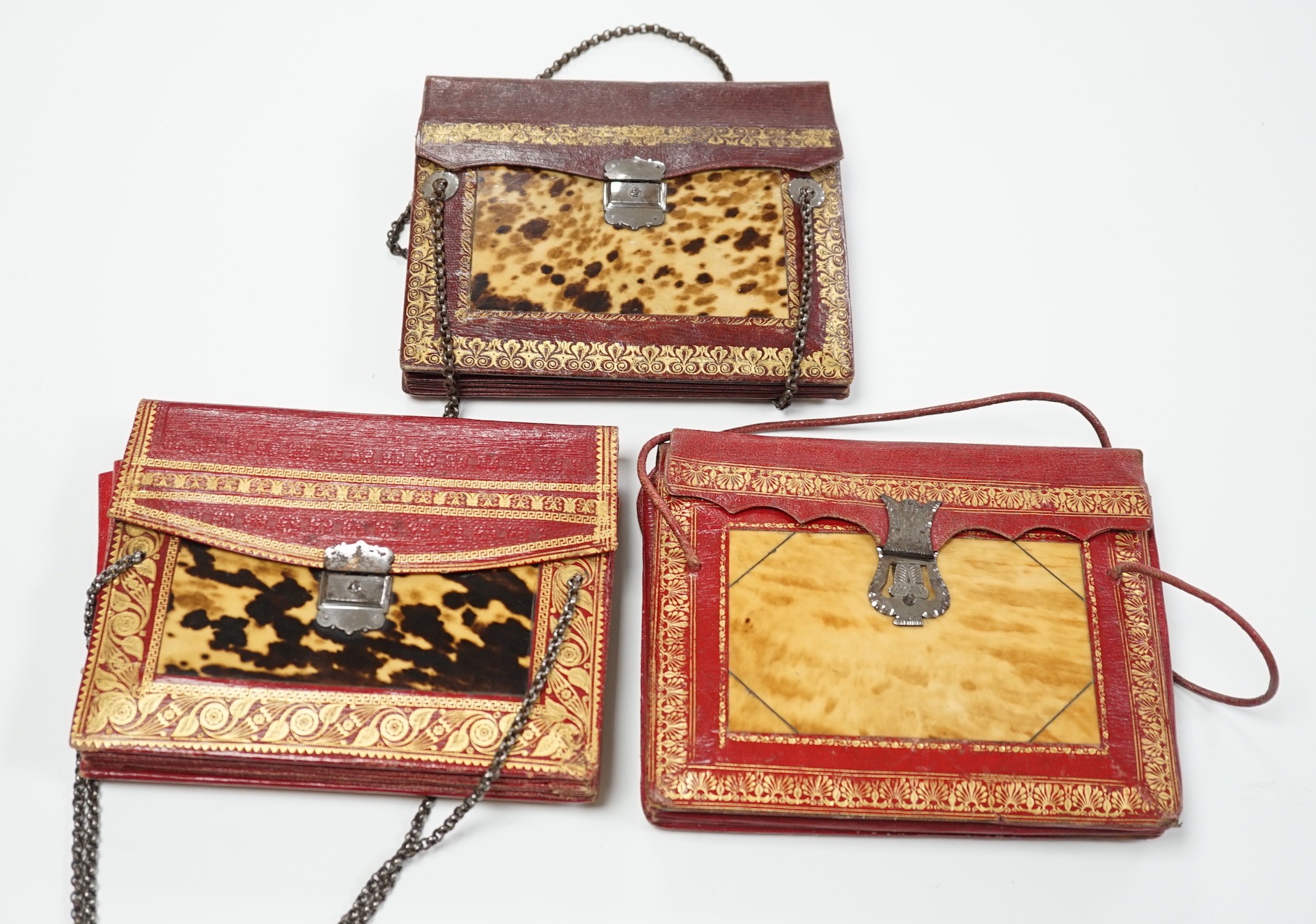Three rare William IV red and burgundy tooled Moroccan leather and tortoiseshell panelled handbags, two with Scottish thistle shaped cut steel clasps